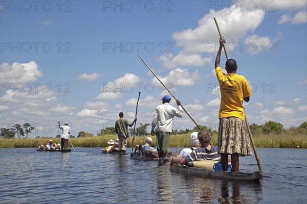 Tourists traveling in traditional wooden canoes