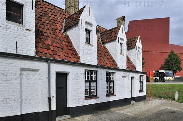 Alley with medieval almshouses and Concert Hall in Bruges