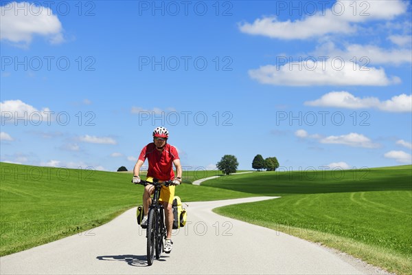 Cyclist on a picture-book country road near Berg