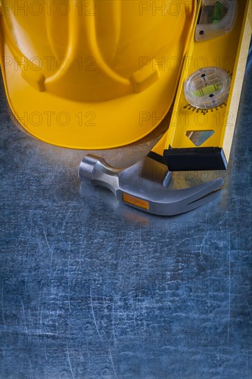Copy space image of claw hammer construction level and building helmet on scratched metallic surface maintenance concept