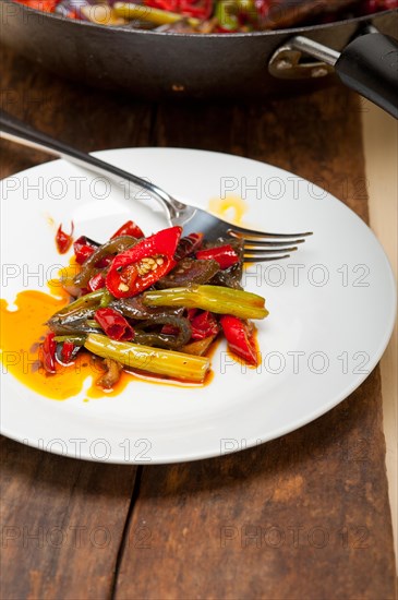 Fried chili pepper and vegetable on a iron wok pan