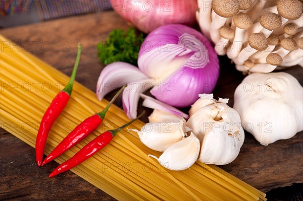 Italian pasta and mushroom sauce raw ingredients over rustic old wood