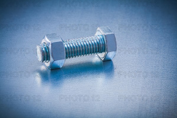 Stainless steel bolt detail with screw nut on metallic background Construction concept