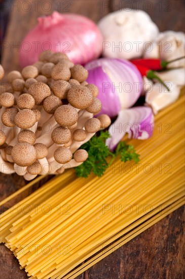 Italian pasta and mushroom sauce raw ingredients over rustic old wood