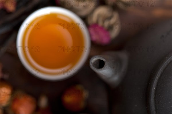 Chinese style herbal floral tea over wood table with raw ingredients