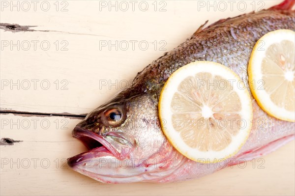 Fresh whole raw fish on a wooden table ready to cook