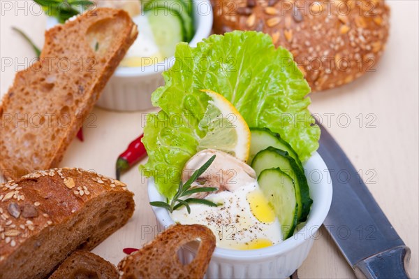 Fresh organic garlic cheese dip salad on a rustic table with bread