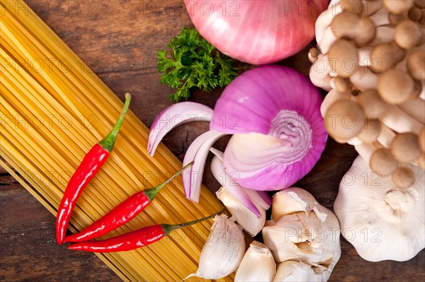 Italian pasta and mushroom sauce raw ingredients over rustic old wood