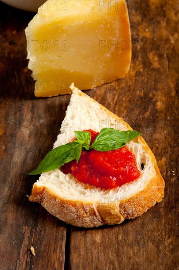 Italian fresh tomato and basil bruschetta with pecorino cheese over old wood