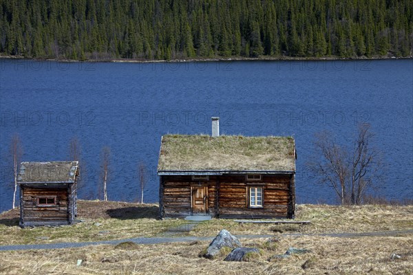 Log cabin with sod roof along lake at Fatmomakke