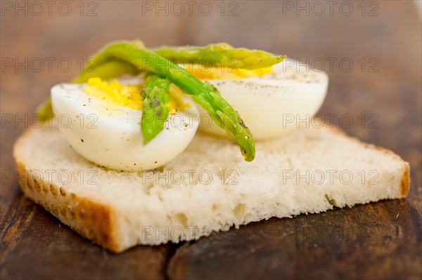 Boiled fresh green asparagus and eggs with extra virgin olive oil with rustic bread