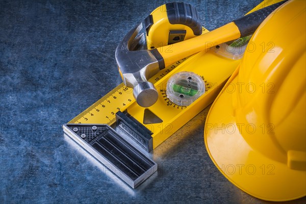 Measuring instruments Claw hammer and construction helmet on scratched metallic background Maintenance concept