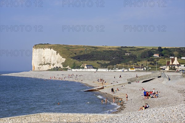 White chalk cliffs and sunbathers on pebble beach at Veulettes-sur-Mer