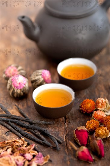 Chinese style herbal floral tea over wood table with raw ingredients