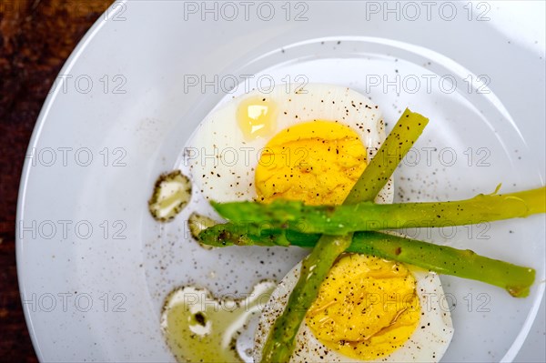 Boiled fresh green asparagus and eggs with extra virgin olive oil