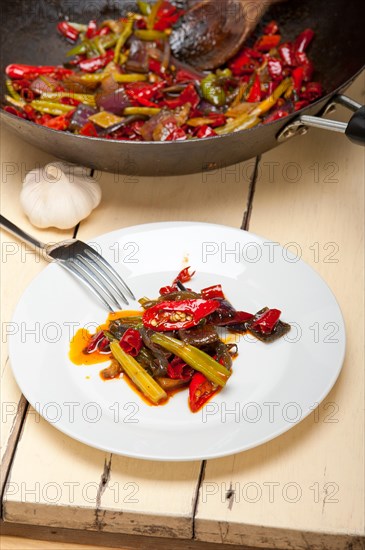 Fried chili pepper and vegetable on a iron wok pan