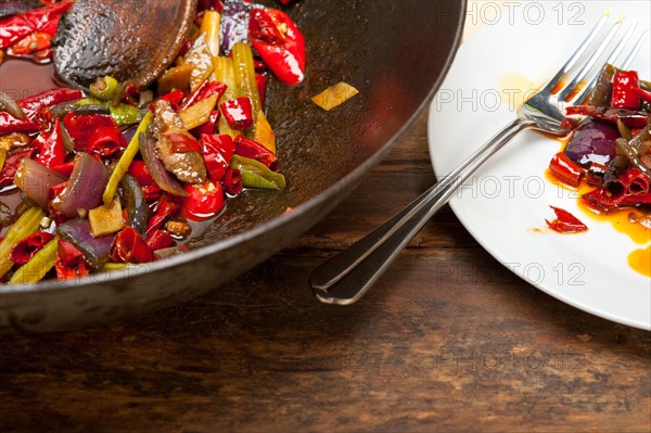 Fried chili pepper and vegetable on a iron wok pan
