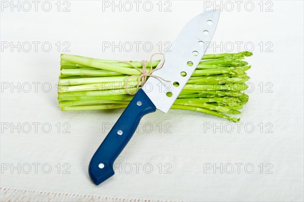 Fresh asparagus from the garden over white background with kitchen knife