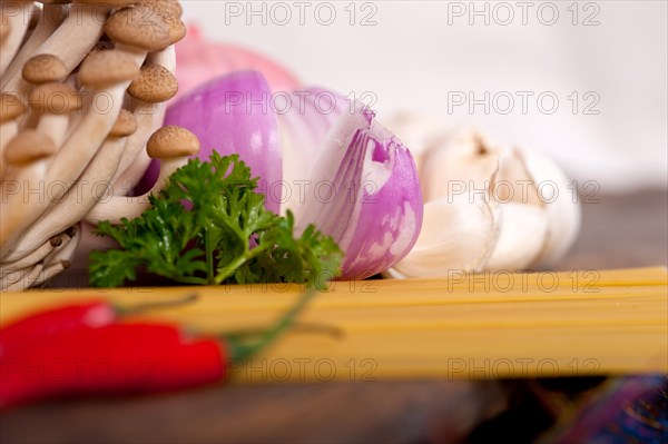 Italian pasta and mushroom sauce raw ingredients over rustic old wood