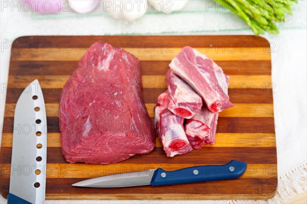 Raw beef and pork ribs with asparagus and herbs ready to cook