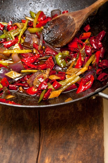 Fried chili pepper and vegetable on a iron wok pan