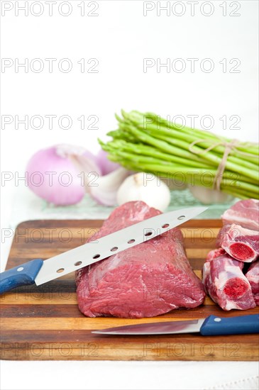 Raw beef and pork ribs with asparagus and herbs ready to cook