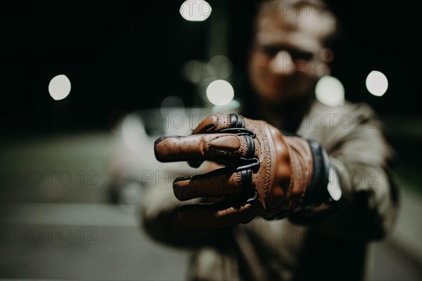 A motorcyclist shows his brown leather touring glove to the camera