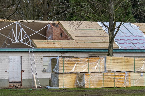 Building fitted with warm pitched roof insulation by installing insulating sandwich panels