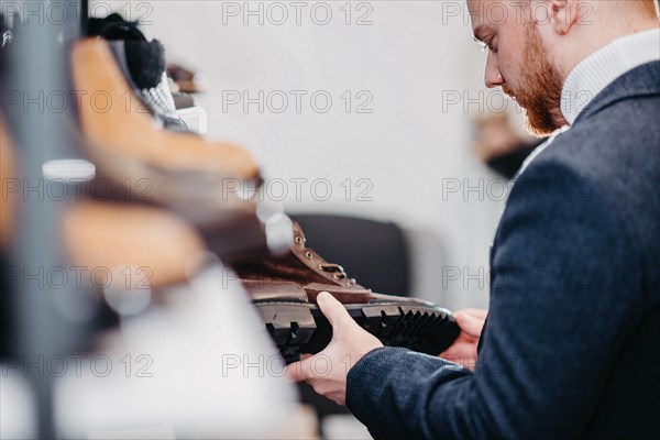 Business successful man businessman chooses shoes for himself in a shoe store