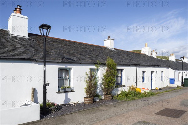 Row of white-harled workers cottages in former slate-mining village Ellenabeich on the isle of Seil