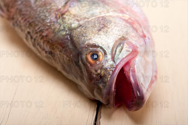 Fresh whole raw fish on a wooden table ready to cook