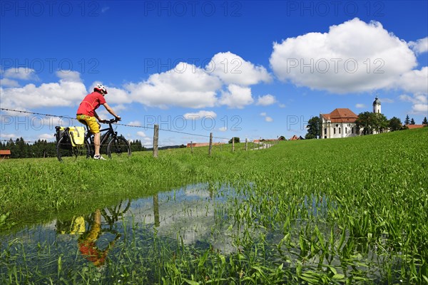 Cyclist with touring bike in front of the Wieskirche