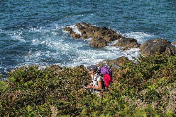 Elderly woman following the sentier des douaniers trail along the Brittany