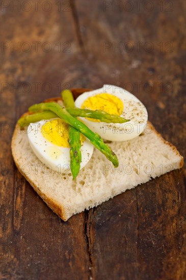 Boiled fresh green asparagus and eggs with extra virgin olive oil with rustic bread