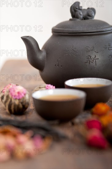 Chinese style herbal floral tea over wood table with raw ingredients