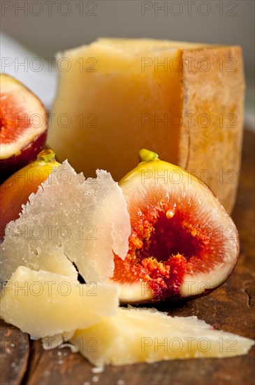 Italian pecorino cheese and fresh figs macro closeup over old wood boards