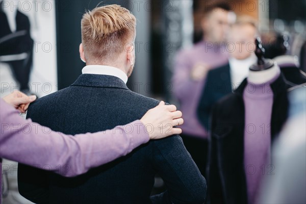 Business successful man businessman chooses a suit in a clothing store