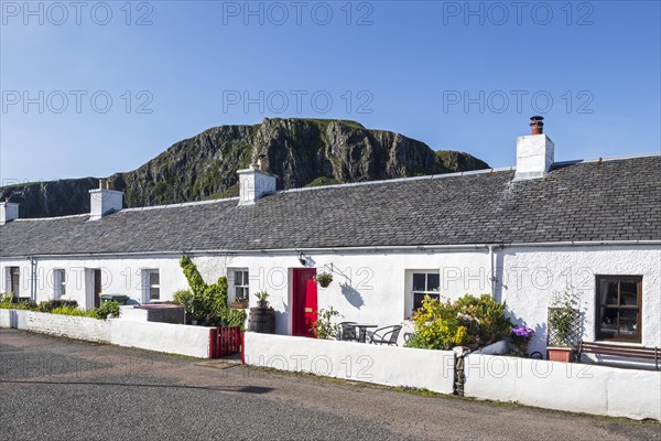 Row of white-harled workers cottages in former slate-mining village Ellenabeich on the isle of Seil