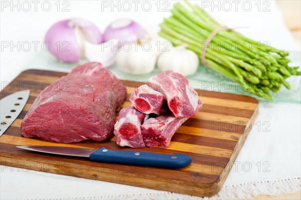 Raw beef and pork ribs with asparagus and herbs ready to cook