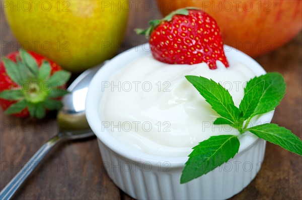 Fresh fruits and whole milk yogurt on a rustic wood table