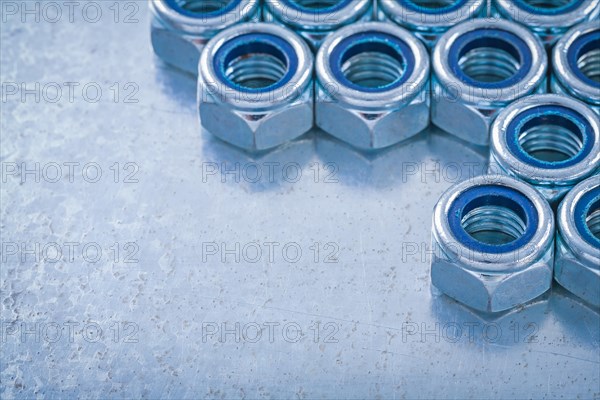 Group of threaded nuts on metallic background horizontal image Design concept