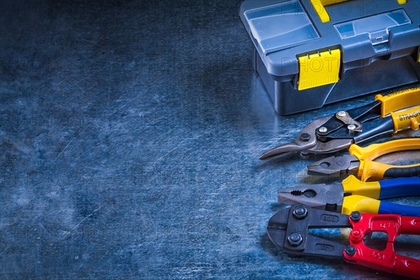 Copy space image of toolbox bolt cutter pliers and tin snips on scratched metallic surface construction concept