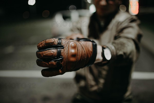 A motorcyclist shows his brown leather touring glove to the camera