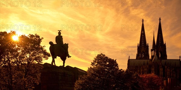 Equestrian statue of Kaiser Wilhelm II backlit with the silhouette of the cathedral