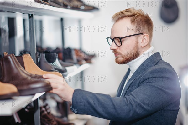 Business successful man businessman chooses shoes for himself in a shoe store