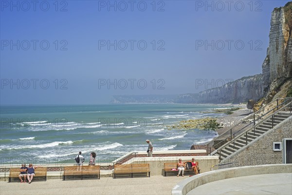 Tourists sunbathing on promenade at seaside resort Yport along the North Sea coast