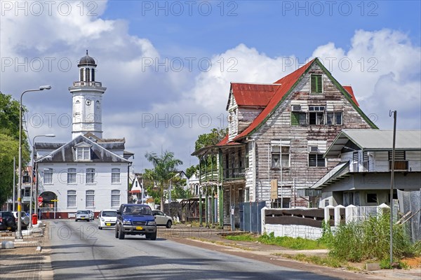 White wooden clock tower of the Ministry of Finance building and colonial houses in the city centre of Paramaribo