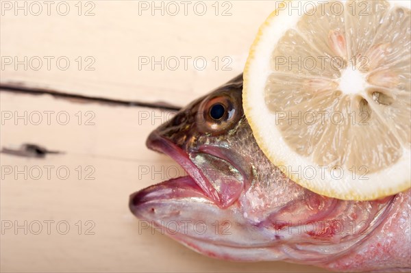 Fresh whole raw fish on a wooden table ready to cook