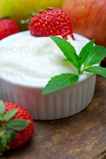 Fresh fruits and whole milk yogurt on a rustic wood table