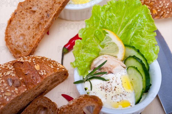 Fresh organic garlic cheese dip salad on a rustic table with bread